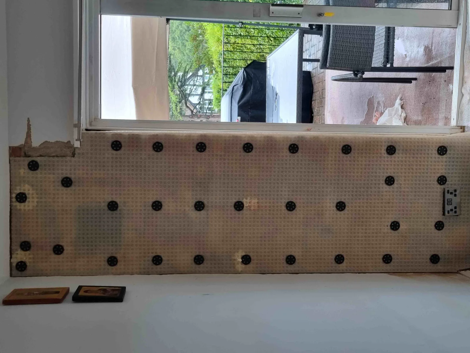 A studded damp-proof membrane fixed to a wall below a window, ready for boarding, from a job this week